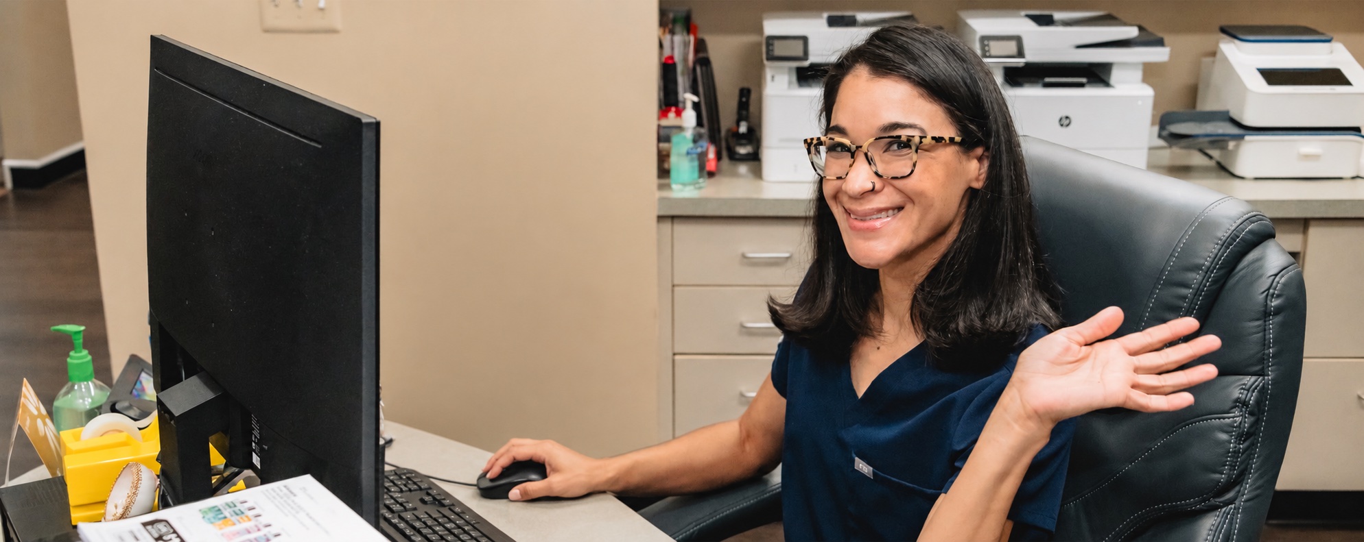 Landmark Smiles team member waving from the front desk