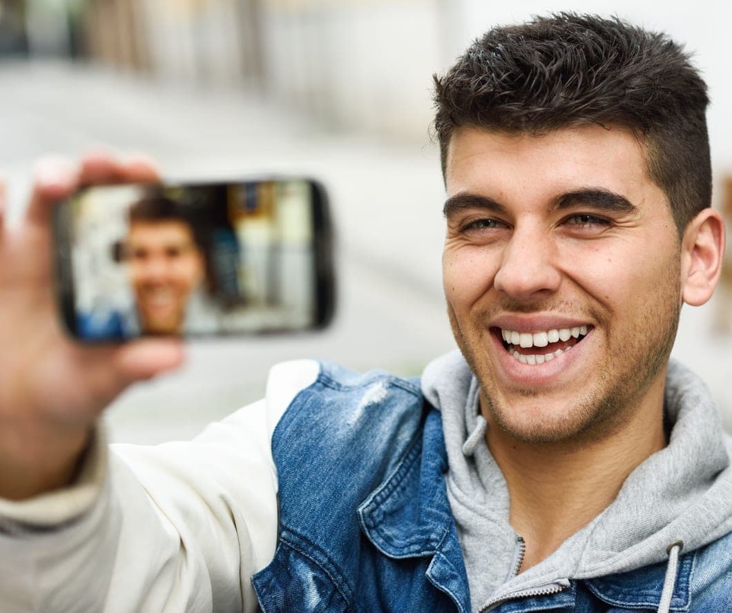 Smiling young man taking a selfie